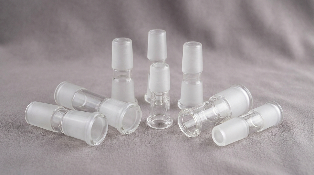 Several clear glass bong joint adapters of different sizes