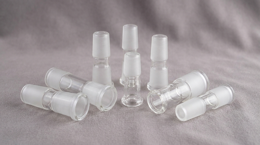 Several clear glass bong joint adapters of different sizes