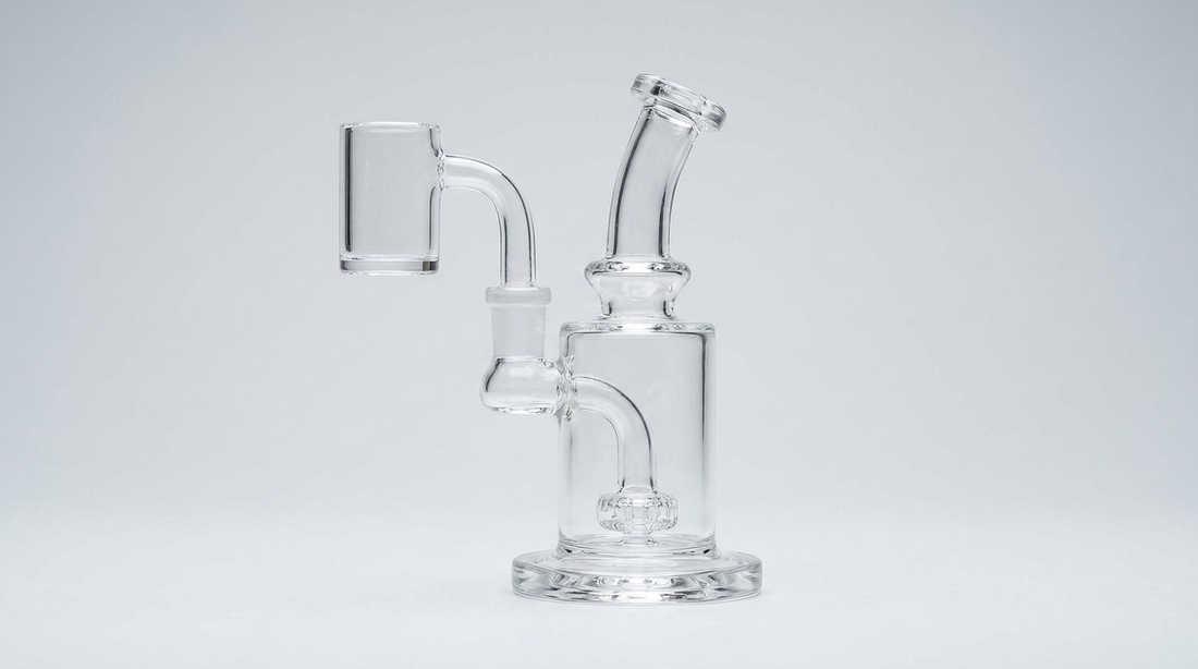 A clear quartz banger seated on a glass dab rig on a gray background