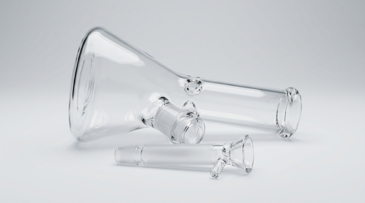 A glass bong with its downstem and bowl removed and resting beside the joint