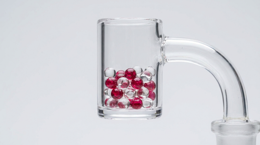 Colorful terp pearls resting inside a clear quartz banger