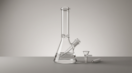 Clear glass beaker bong with its bowl slide and downstem laid beside it